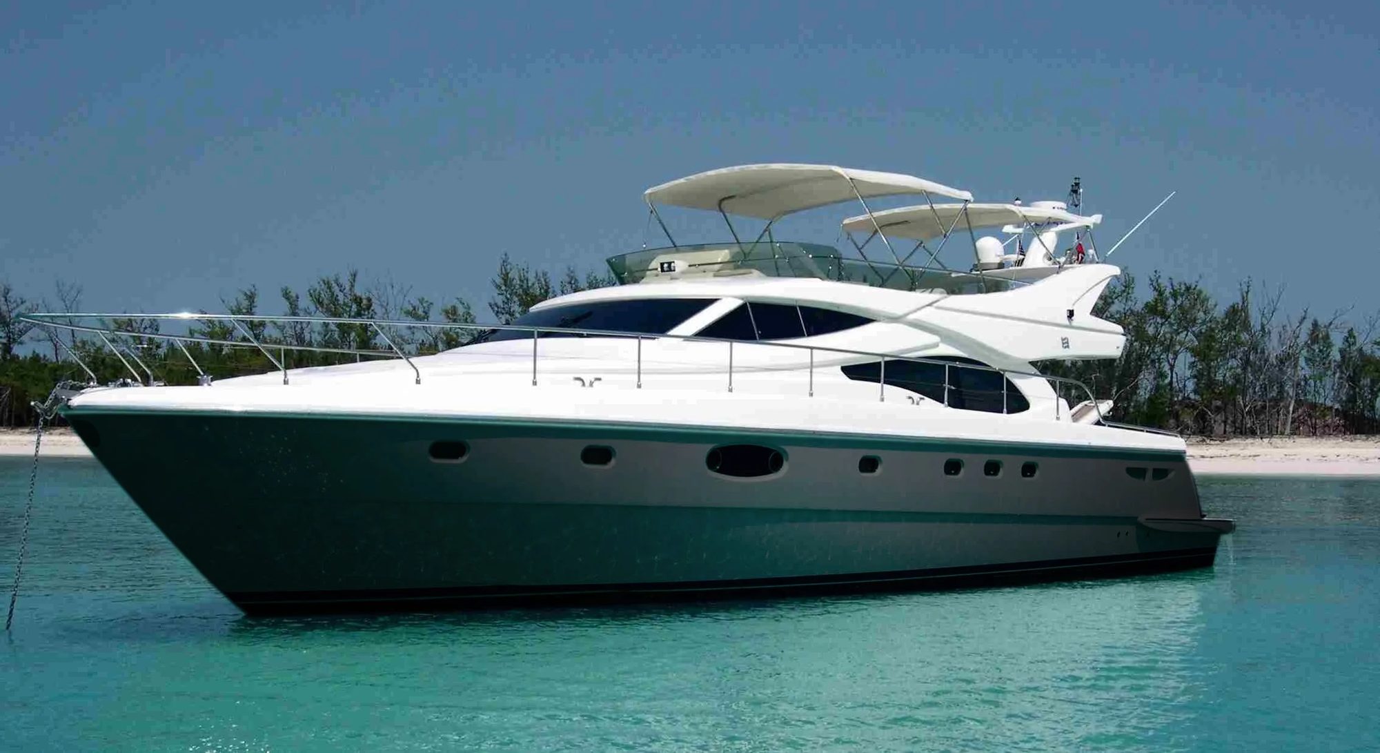 Motor yacht finished in a Wrap Marine hull wrap, moored in clear water